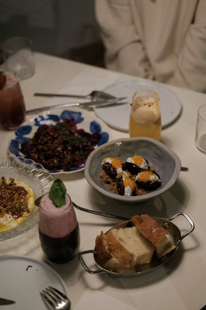 Elegant dinner table setup featuring gourmet dishes and drinks, perfect for culinary enthusiasts.